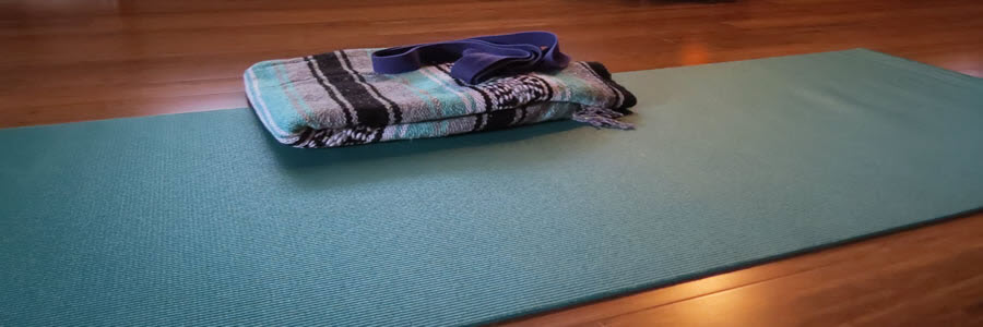 Yoga mat with a blanket and band on top